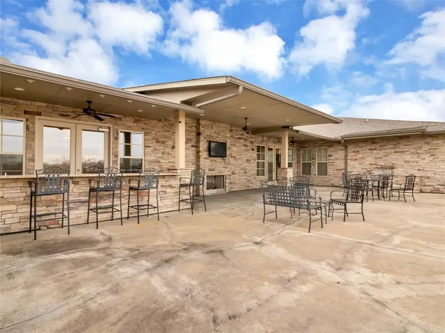 a view of a patio with a table and chairs and potted plants