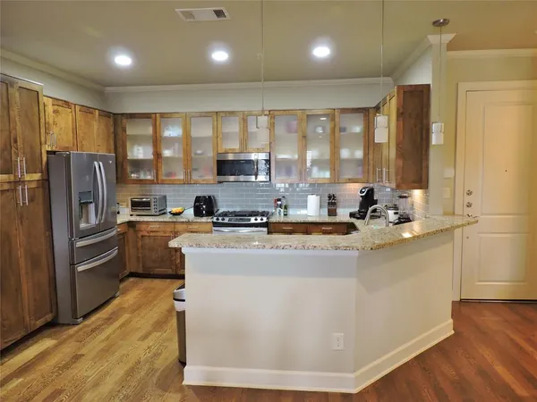 a kitchen with stainless steel appliances granite countertop a refrigerator a sink a stove and a refrigerator