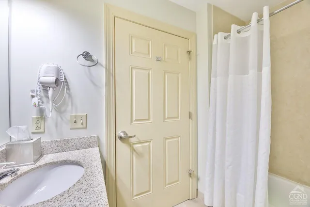 a bathroom with a granite countertop sink vanity mirror and shower