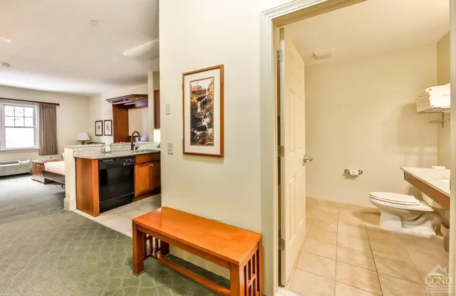 a living room with a furniture and a open kitchen view