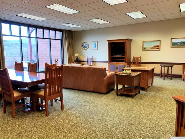 a living room with furniture a flat screen tv and a large window