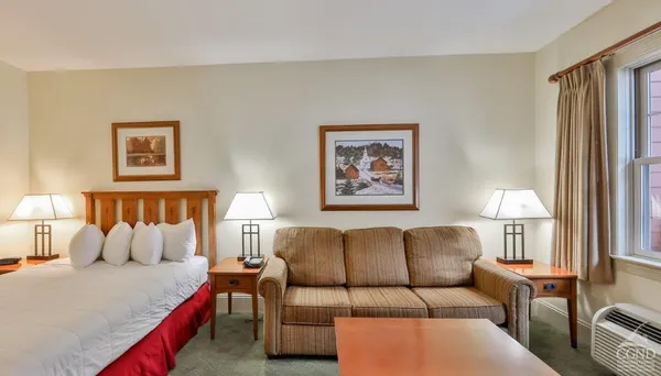 a bed room with couch and painting on the wall