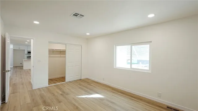 a view of empty room with wooden floor and windows
