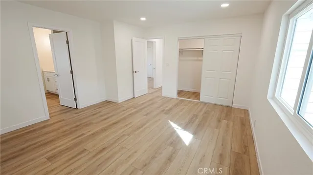 a view of empty room with wooden floor and window