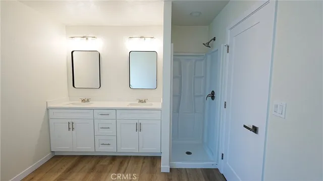 a bathroom with a double vanity sink mirror and shower