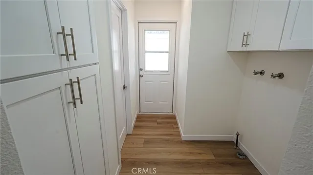 a view of a hallway with wooden floor and closet