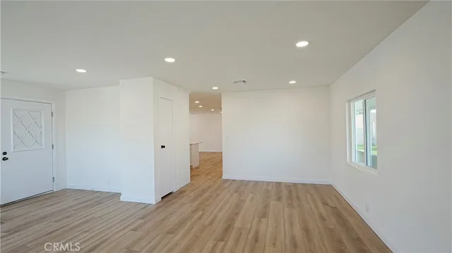 a view of a room with wooden floor and window