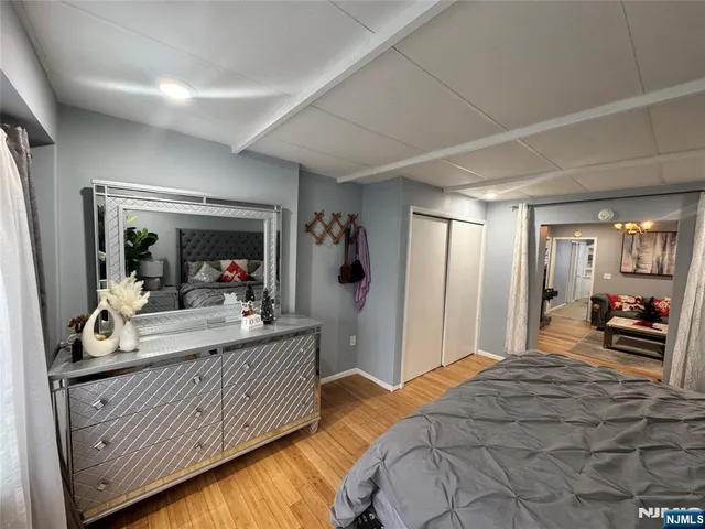 a bedroom with a bed and a large mirror on the dresser