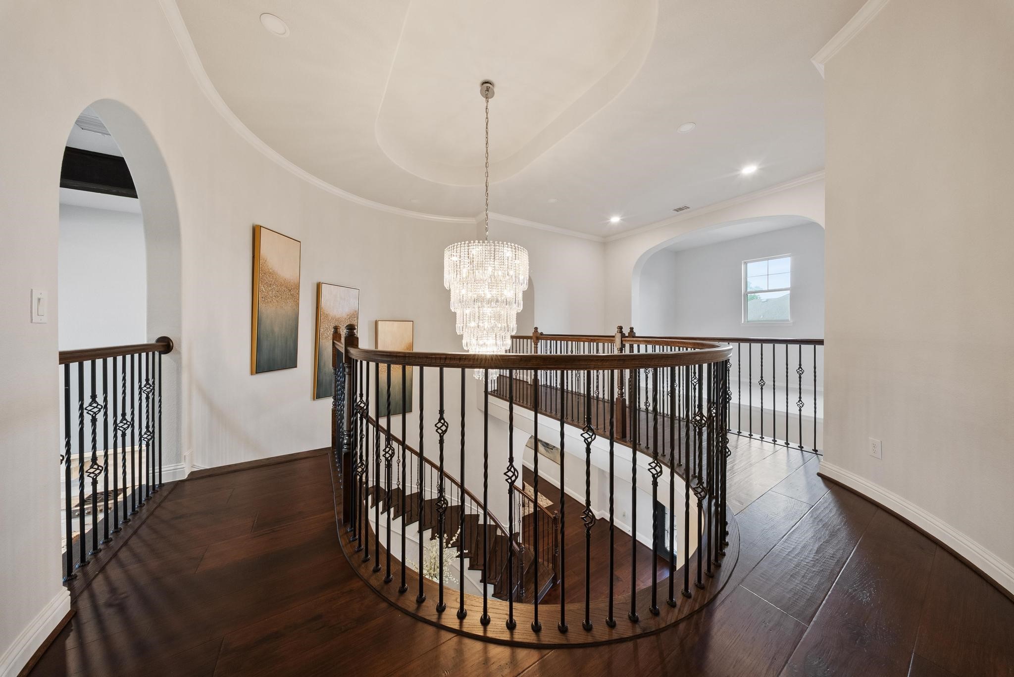 5403 Rouchel Brook Lane Sugar Land, TX 77479 - Photo 23 of 42 Elegant upstairs landing highlighted by a statement chandelier and curved wrought iron railing. Overlooking the front entry on one-side and the expansive living room on the other.