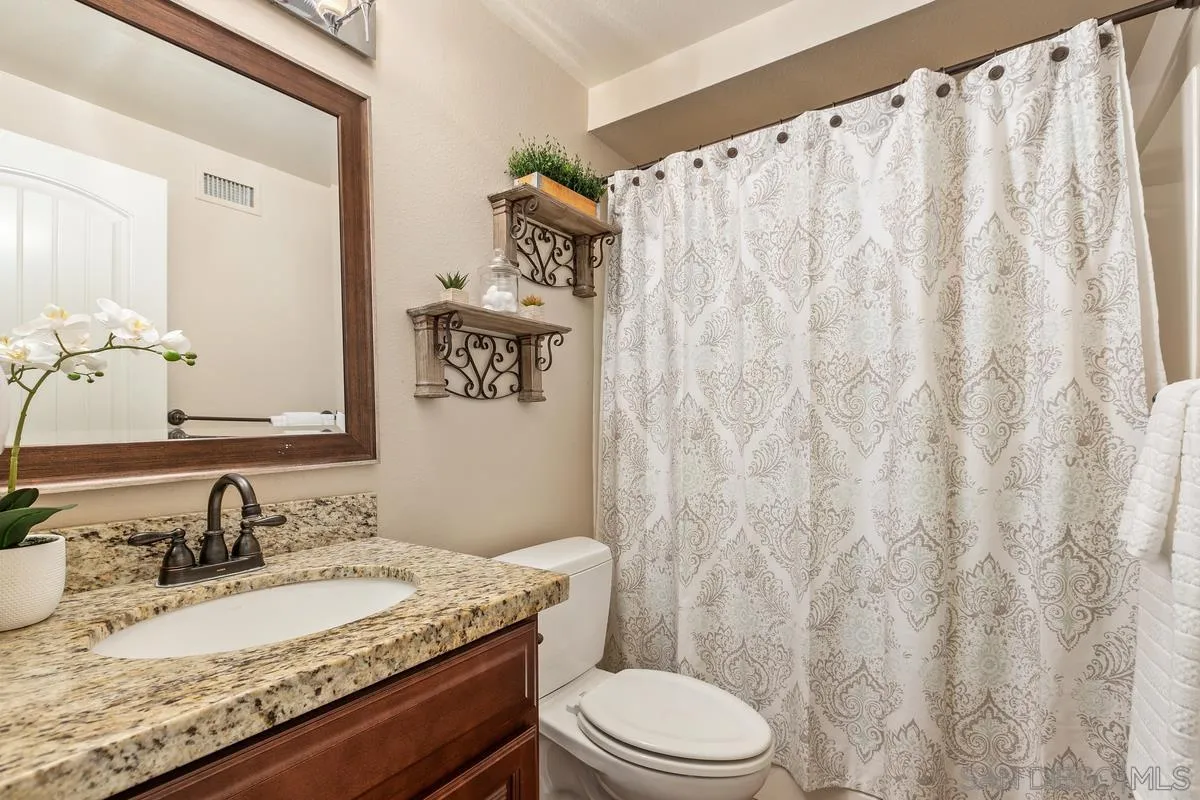 14437 Hillndale Way Poway, CA 92064 - Photo 11 of 35 a bathroom with a granite countertop sink and a mirror