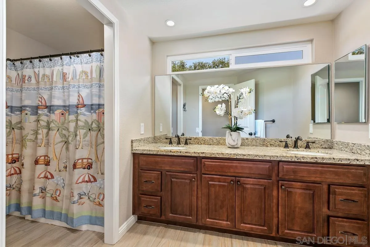 14437 Hillndale Way Poway, CA 92064 - Photo 19 of 35 a bathroom with a granite countertop sink and a mirror