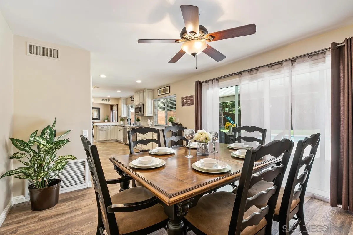 14437 Hillndale Way Poway, CA 92064 - Photo 7 of 35 a view of a dining room and livingroom with furniture wooden floor and a chandelier