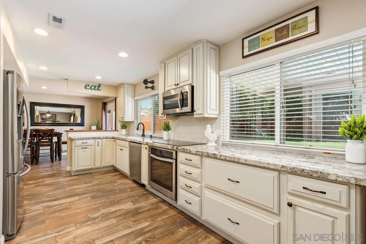 14437 Hillndale Way Poway, CA 92064 - Photo 8 of 35 a open kitchen with granite countertop a stove a sink a refrigerator dining table and chairs