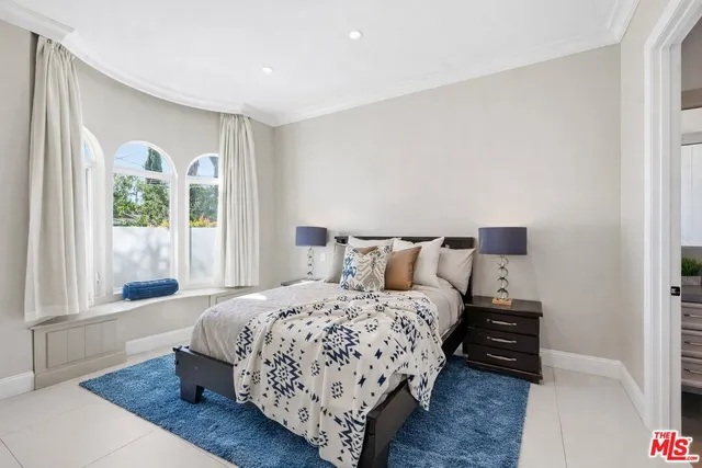 a bedroom with a large bed and a potted plant