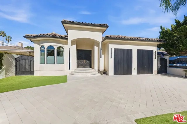 a view of a house with a yard and potted plants