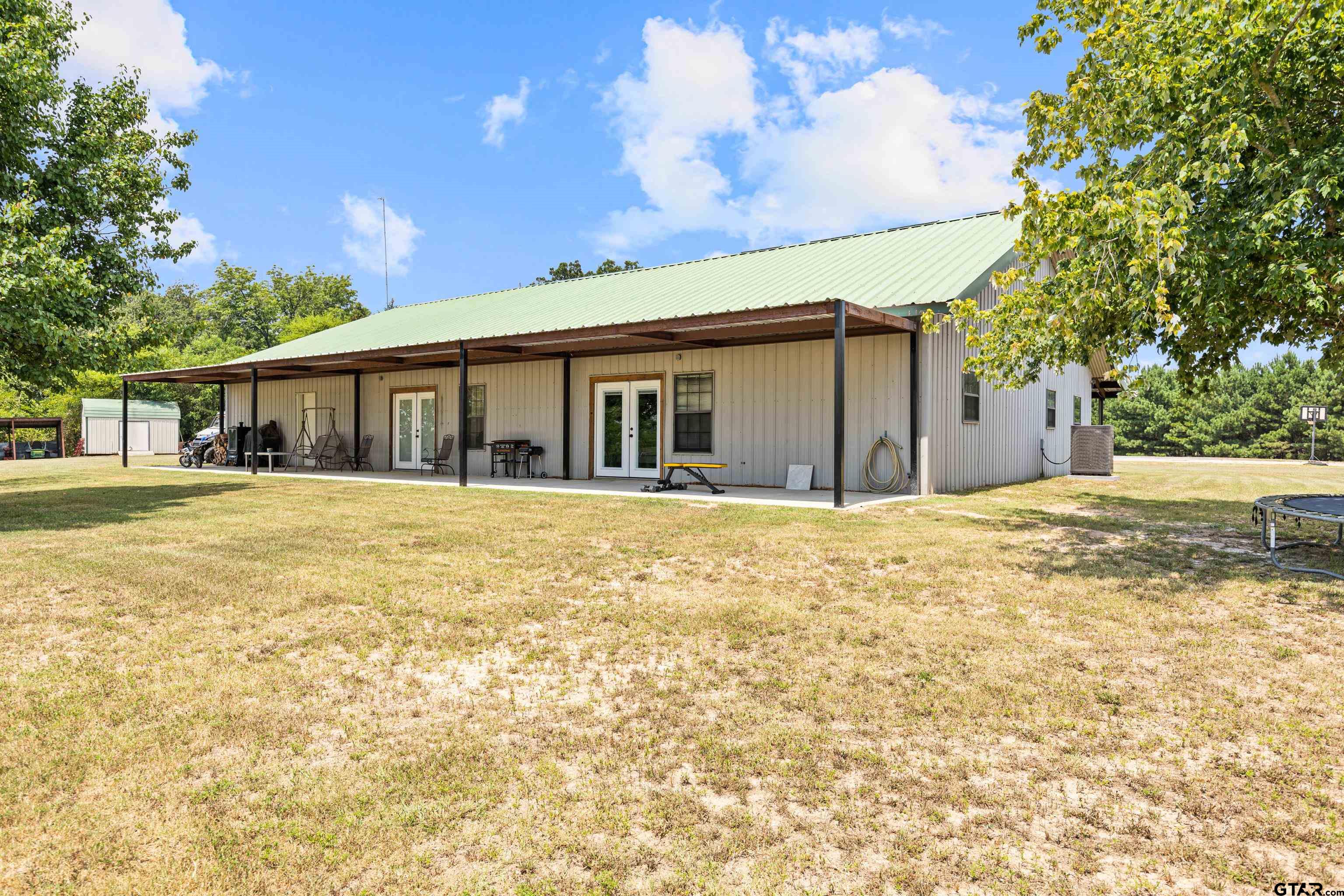 423 County Road 4306 Naples, TX 75568 - Photo 17 of 47 a backyard of a house with large trees and outdoor space