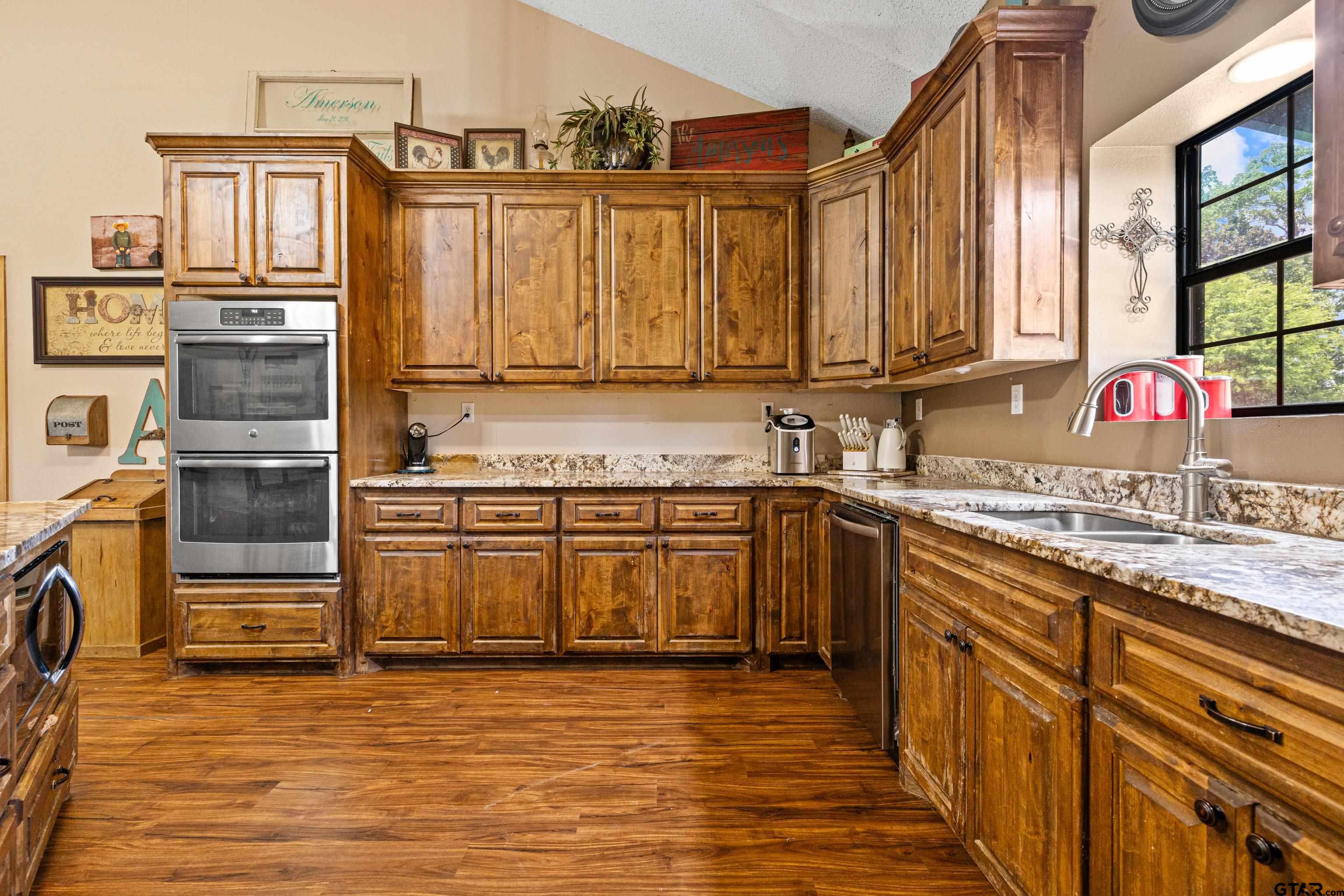 423 County Road 4306 Naples, TX 75568 - Photo 20 of 47 a kitchen with stainless steel appliances granite countertop a sink stove and cabinets