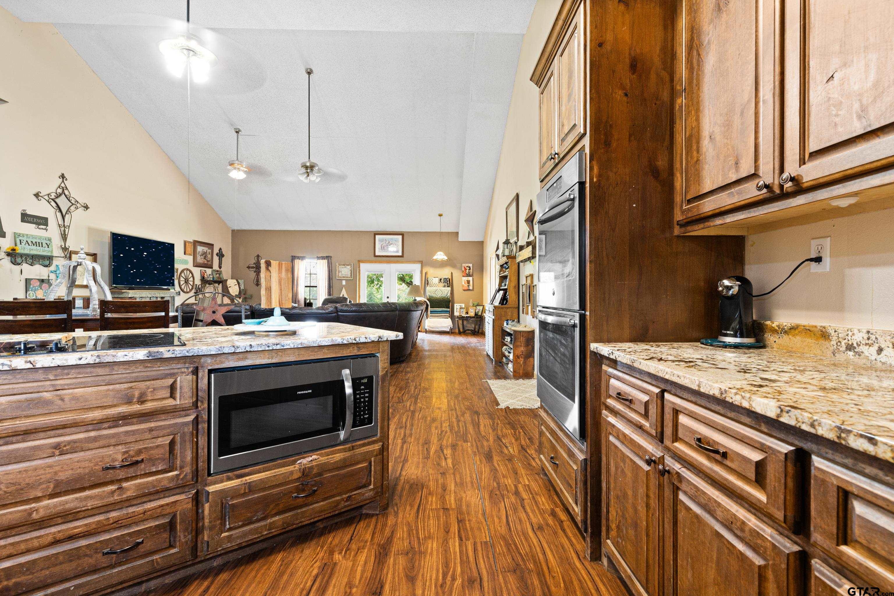 423 County Road 4306 Naples, TX 75568 - Photo 21 of 47 a kitchen with stainless steel appliances granite countertop a stove and a wooden floors