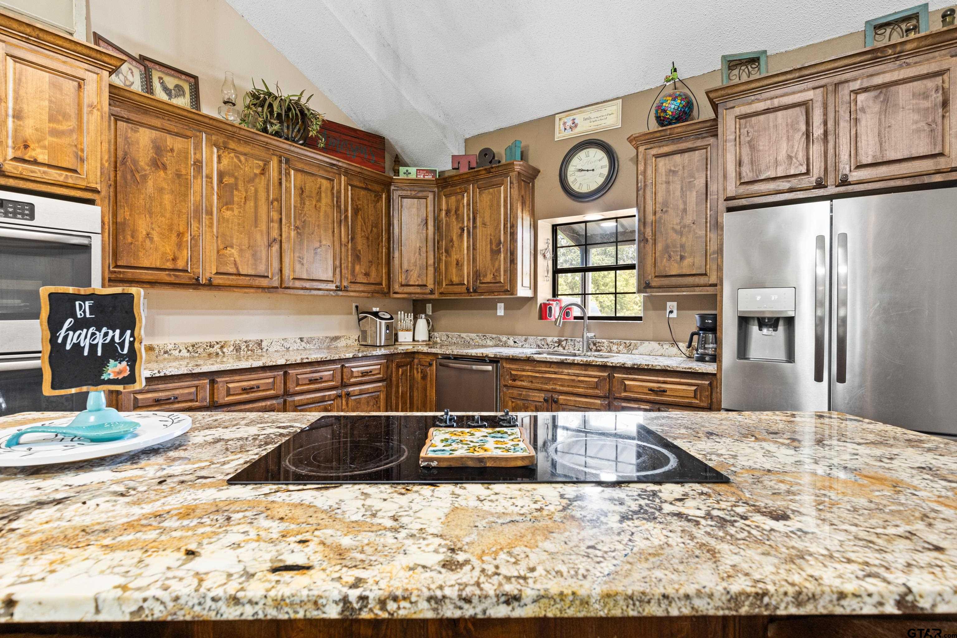 423 County Road 4306 Naples, TX 75568 - Photo 23 of 47 a kitchen with stainless steel appliances granite countertop a stove a sink and a microwave