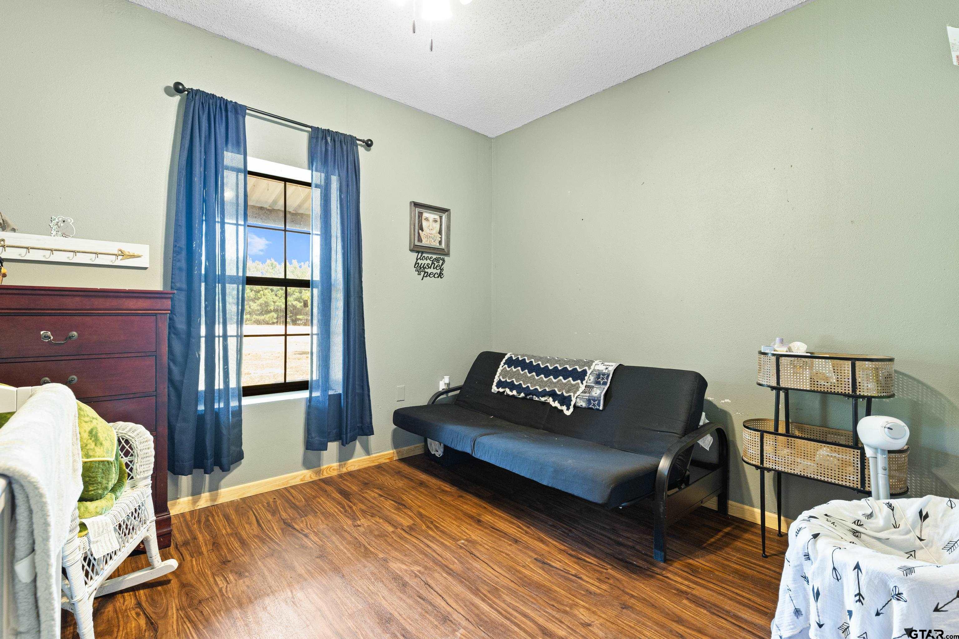 423 County Road 4306 Naples, TX 75568 - Photo 28 of 47 a bedroom with a bed and wooden floor