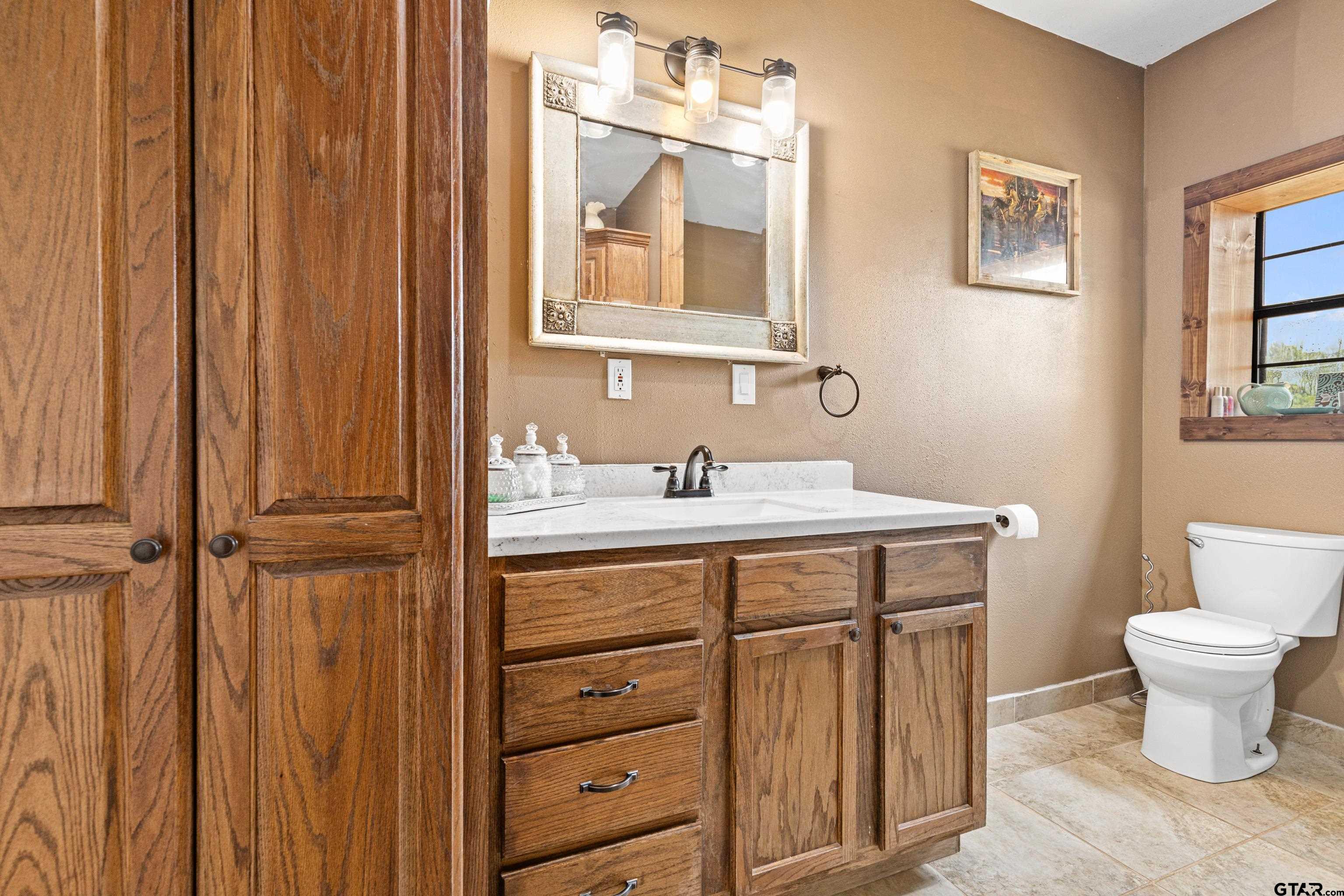423 County Road 4306 Naples, TX 75568 - Photo 33 of 47 a bathroom with a toilet sink and mirror