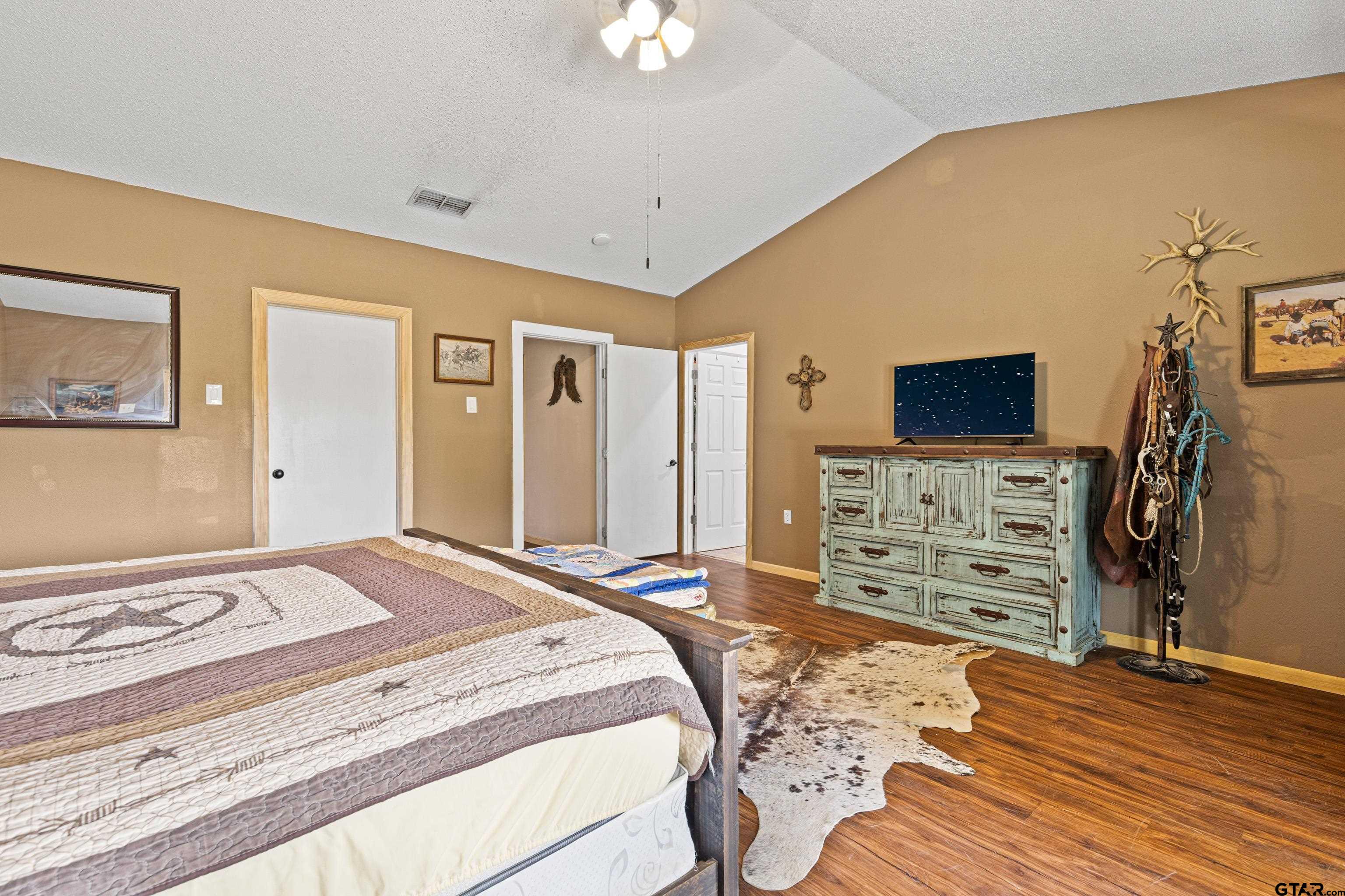 423 County Road 4306 Naples, TX 75568 - Photo 35 of 47 a bedroom with a bed and a flat tv screen on dresser