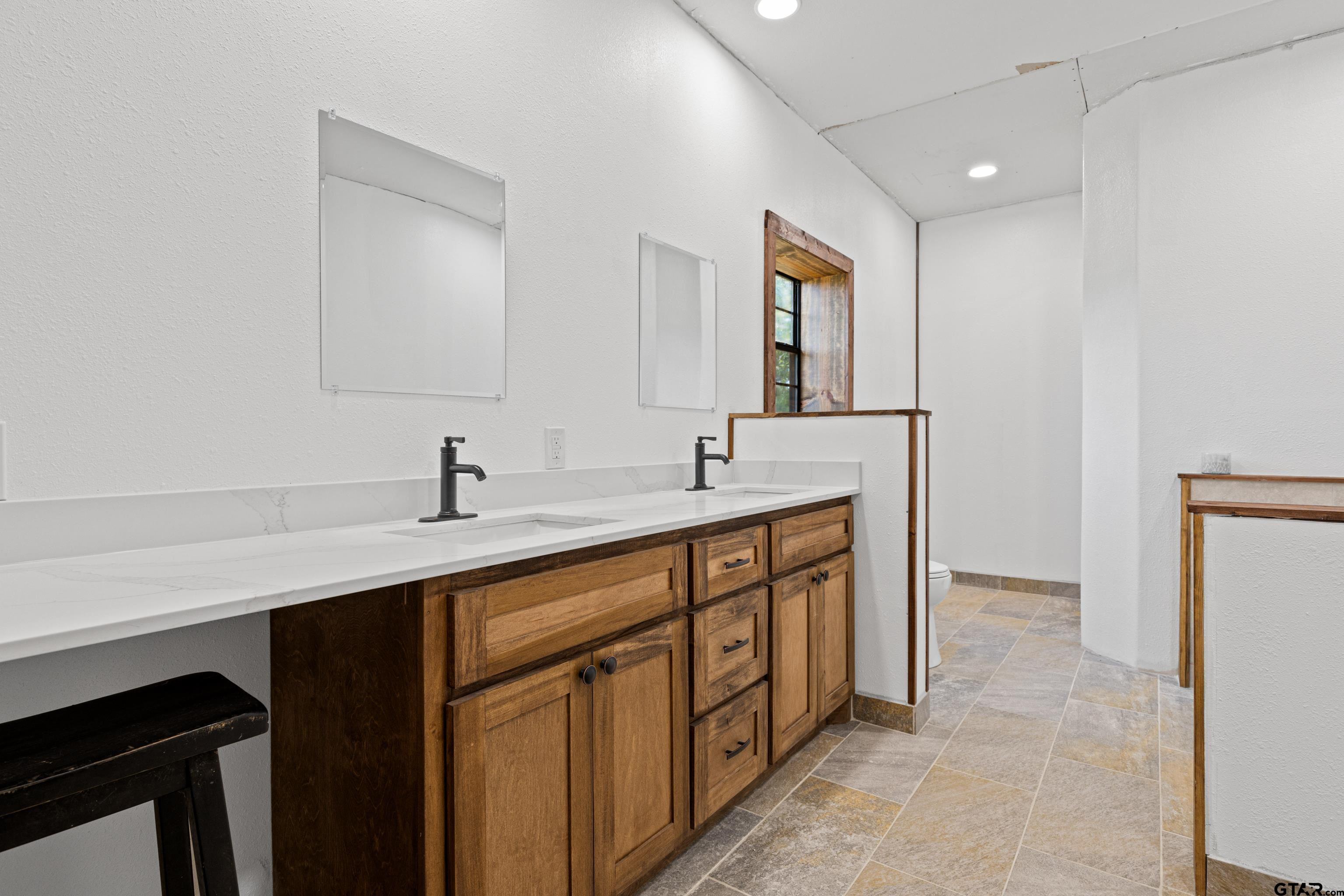 423 County Road 4306 Naples, TX 75568 - Photo 38 of 47 a spacious bathroom with a double vanity sink and mirror
