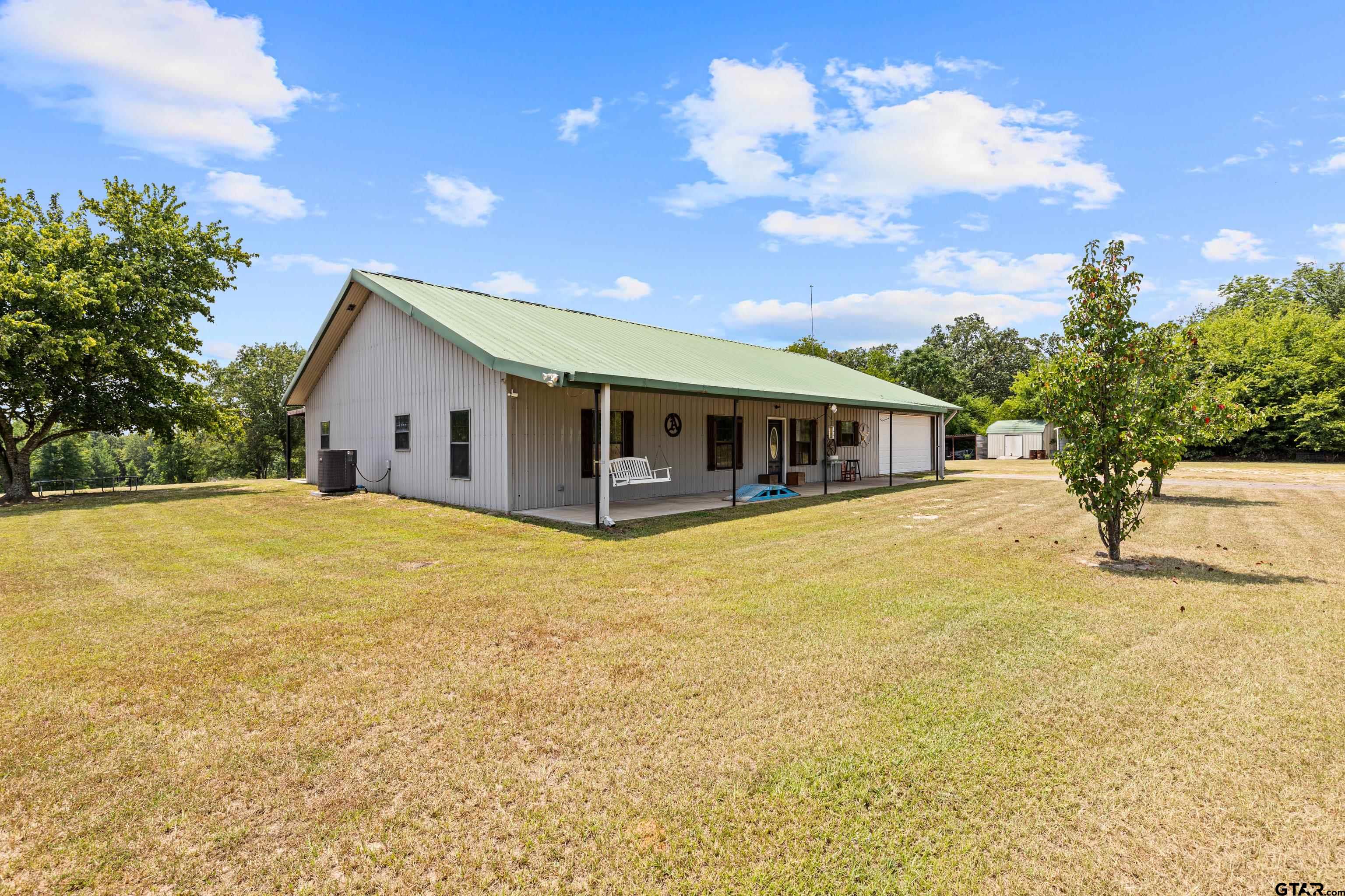 423 County Road 4306 Naples, TX 75568 - Photo 4 of 47 a front view of house with yard and trees in the background