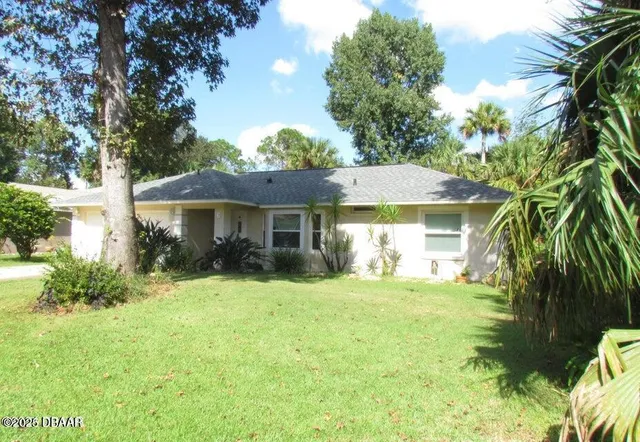 a view of a house with a yard and sitting area