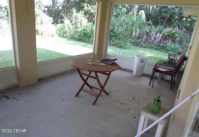 a view of a patio with two chairs next to a yard