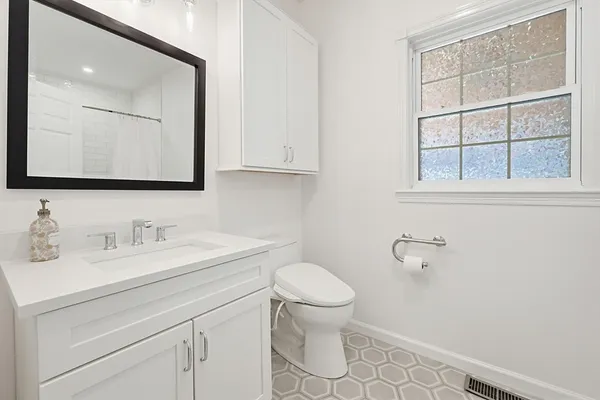 a bathroom with a toilet sink and mirror