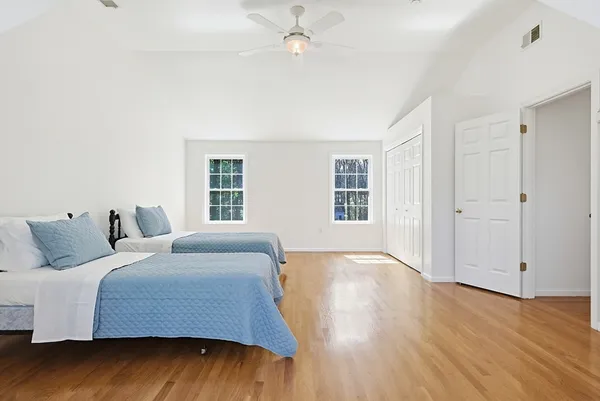 a bedroom with a bed and wooden floor