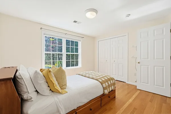 a bedroom with a bed and wooden floor