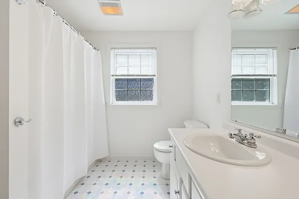 a bathroom with a sink toilet and window