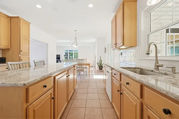 a large kitchen with granite countertop a sink and a counter top space