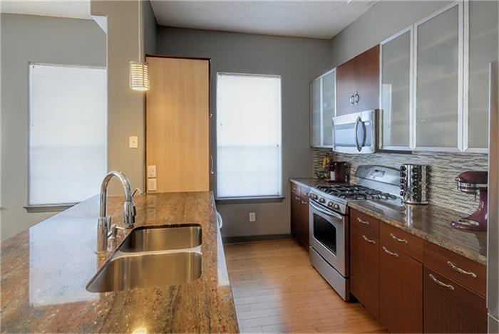 1414 Emancipation Avenue, Unit A Houston, TX 77003 - Photo 7 of 22 a kitchen with stainless steel appliances granite countertop a sink stove and refrigerator