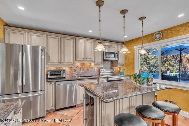 a kitchen with stainless steel appliances granite countertop a sink a stove and refrigerator