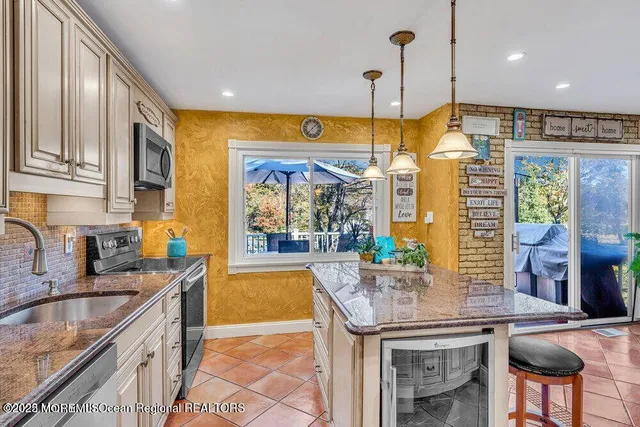a kitchen with stainless steel appliances granite countertop a sink a stove and a wooden floors