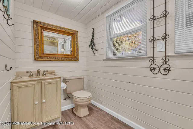 a bathroom with a toilet sink vanity and window