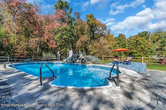 a swimming pool with outdoor seating and yard