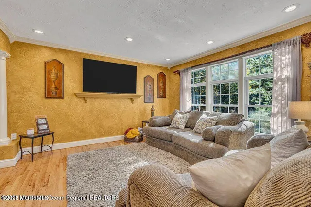 a living room with furniture floor to ceiling window and a flat screen tv