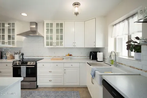 a kitchen with a stove window and cabinets
