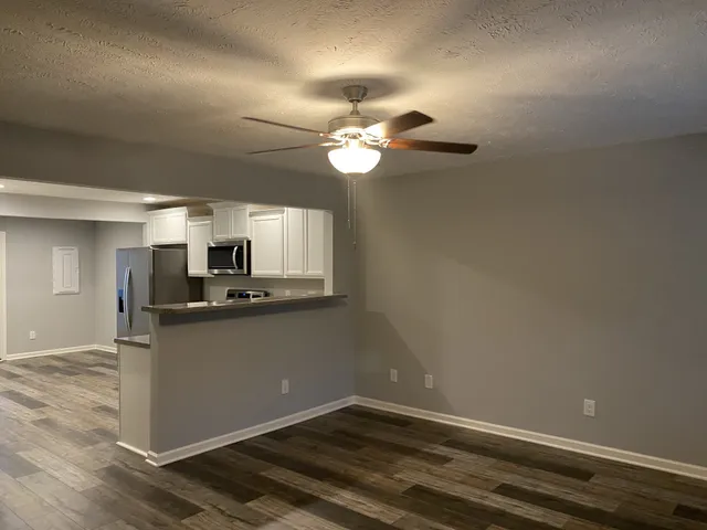 a kitchen with granite countertop cabinets stainless steel appliances and a chandelier