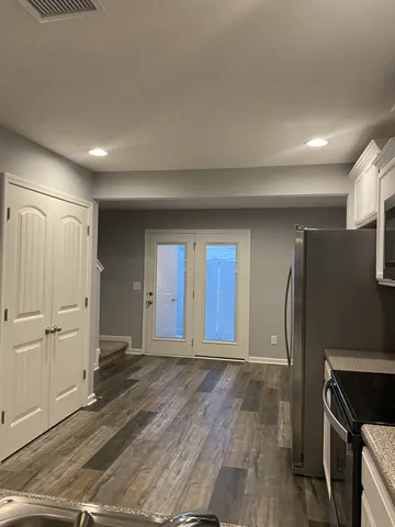 a view of an empty room with wooden floor and a cabinet