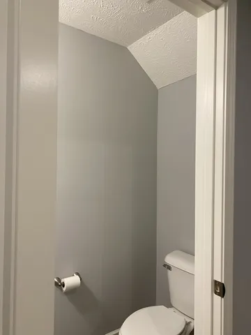 a white toilet sitting next to a white sink and vanity