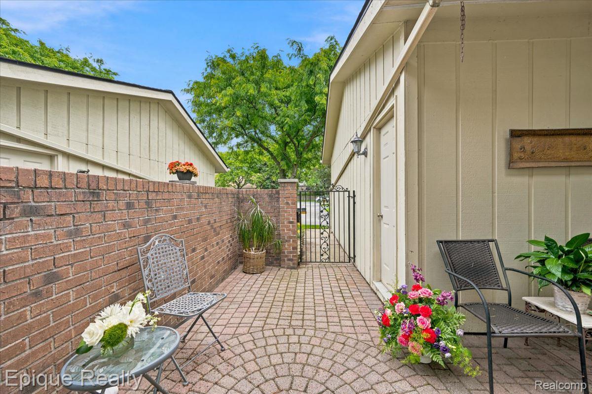 26 Kirks Court Rochester, MI 48309 - Photo 6 of 44 Private outdoor patio featuring a brick privacy wall and circular paver flooring