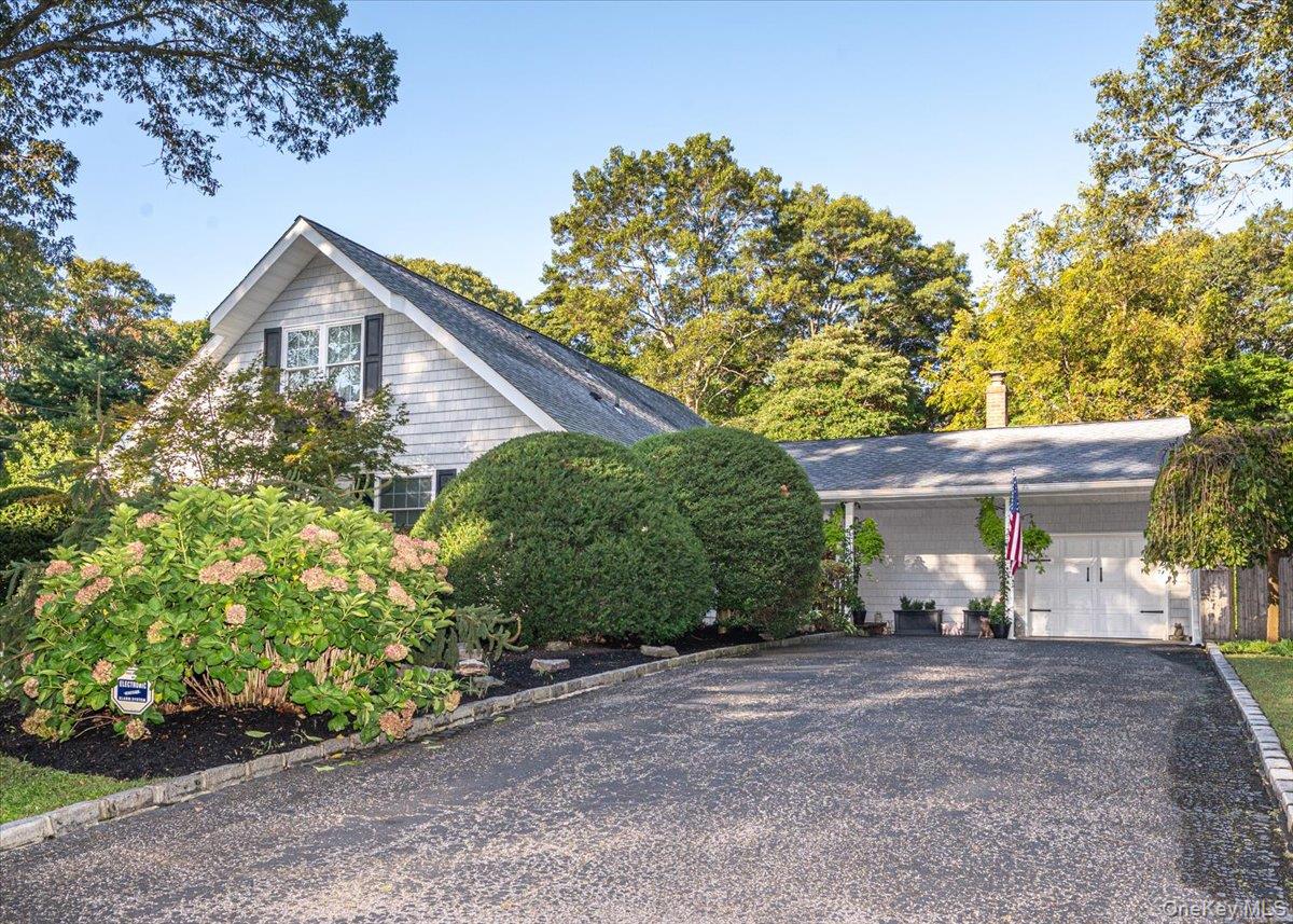 View of property exterior with gravel driveway and a garage