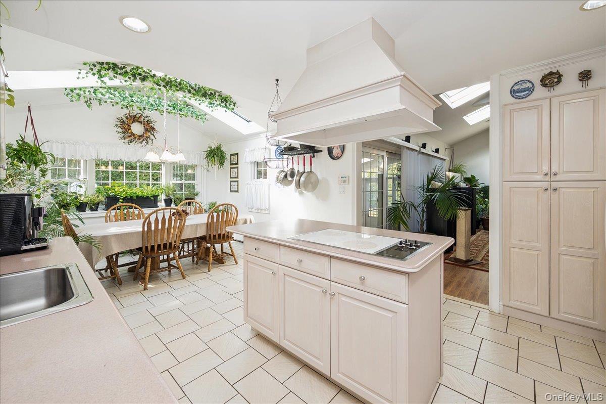 346 Ridgefield Road Hauppauge, NY 11788 - Photo 18 of 45 Kitchen featuring a skylight, lofted ceiling, electric cooktop, premium range hood, and recessed lighting