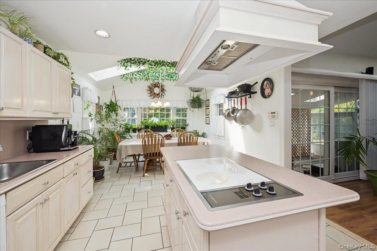 346 Ridgefield Road Hauppauge, NY 11788 - Photo 19 of 45 Kitchen featuring custom range hood, electric cooktop, a skylight, a center island, and vaulted ceiling