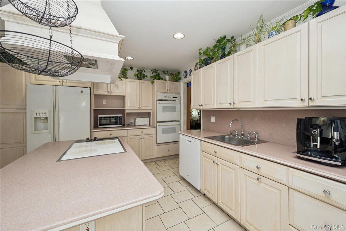 346 Ridgefield Road Hauppauge, NY 11788 - Photo 21 of 45 Kitchen with recessed lighting, white appliances, range hood, light countertops, and light tile patterned flooring